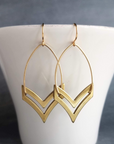 chevron earrings by chokha india hanging from a cup 
