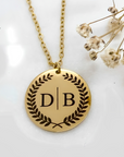 pendant in shape of circle with chain it is gold plated and has two initials marked on it 