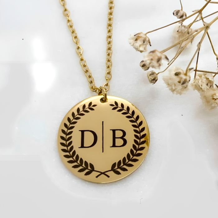 pendant in shape of circle with chain it is gold plated and has two initials marked on it 