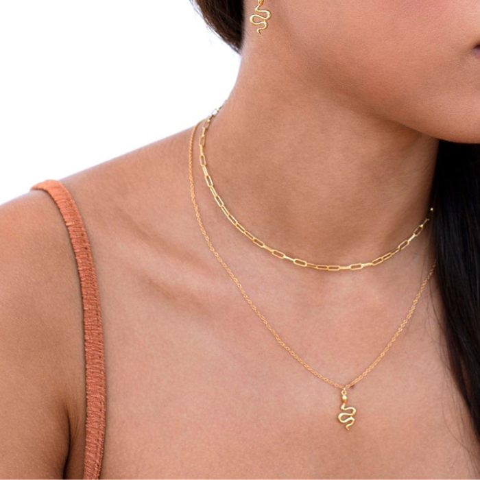 model wearing dainty snake pendant with dainty snake earrings by chokha india which are gold plated made of 92.5 sterling silver 