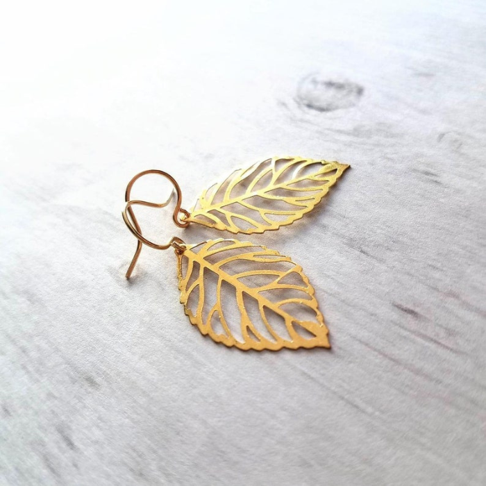 gold plated leaf shaped earrings which are made of 92.5 sterling silver by chokha india kept side by side