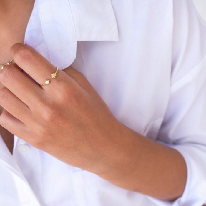 Model wearing white shirt with dainty two star ring which is gold plated 