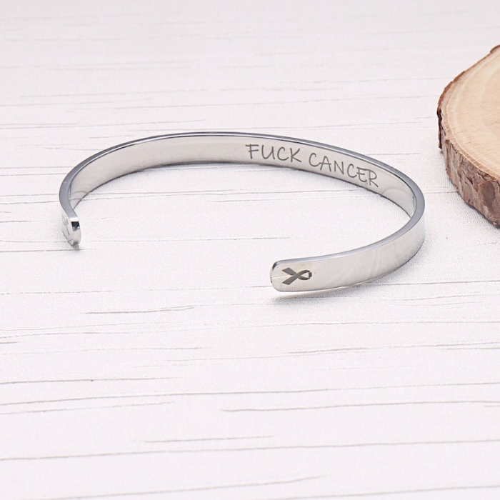 sterling silver bracelet cuff designed specially for cancer patients and survivors . A quote fuck cancer is written on the inside